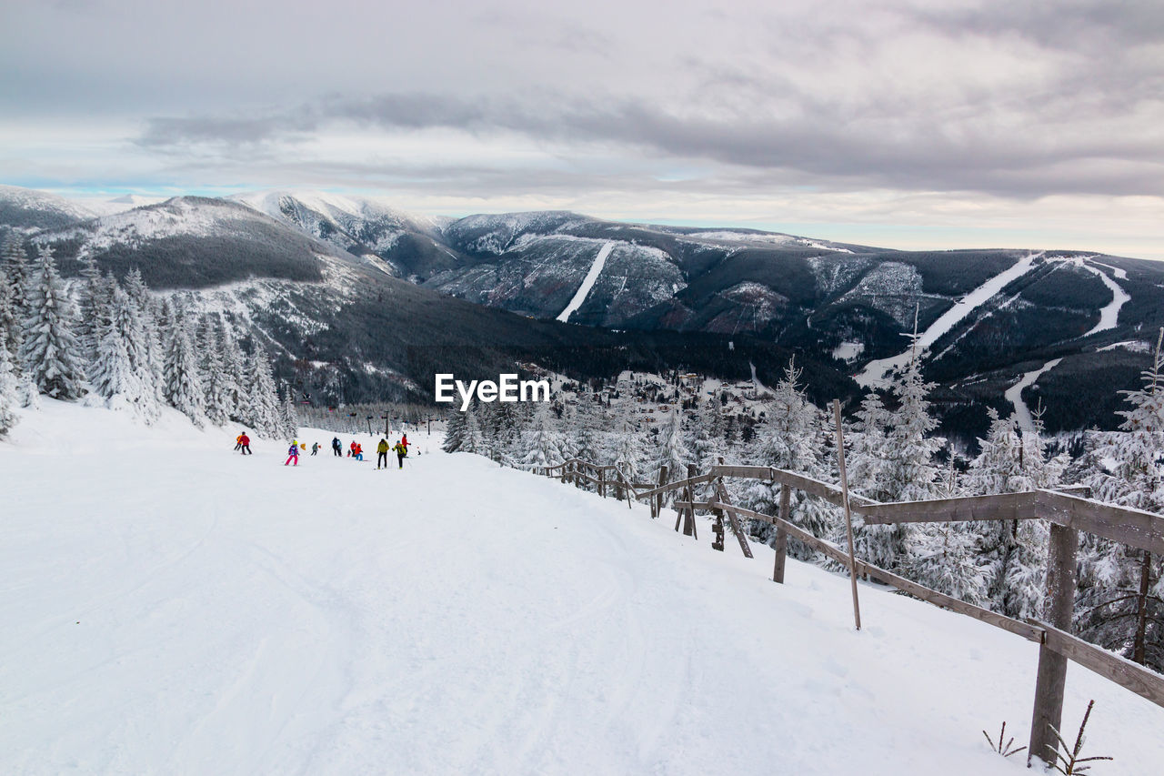 People on snowcapped mountains against sky