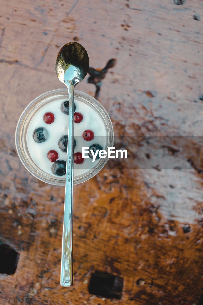 High angle view of yogurt in bowl on wooden table