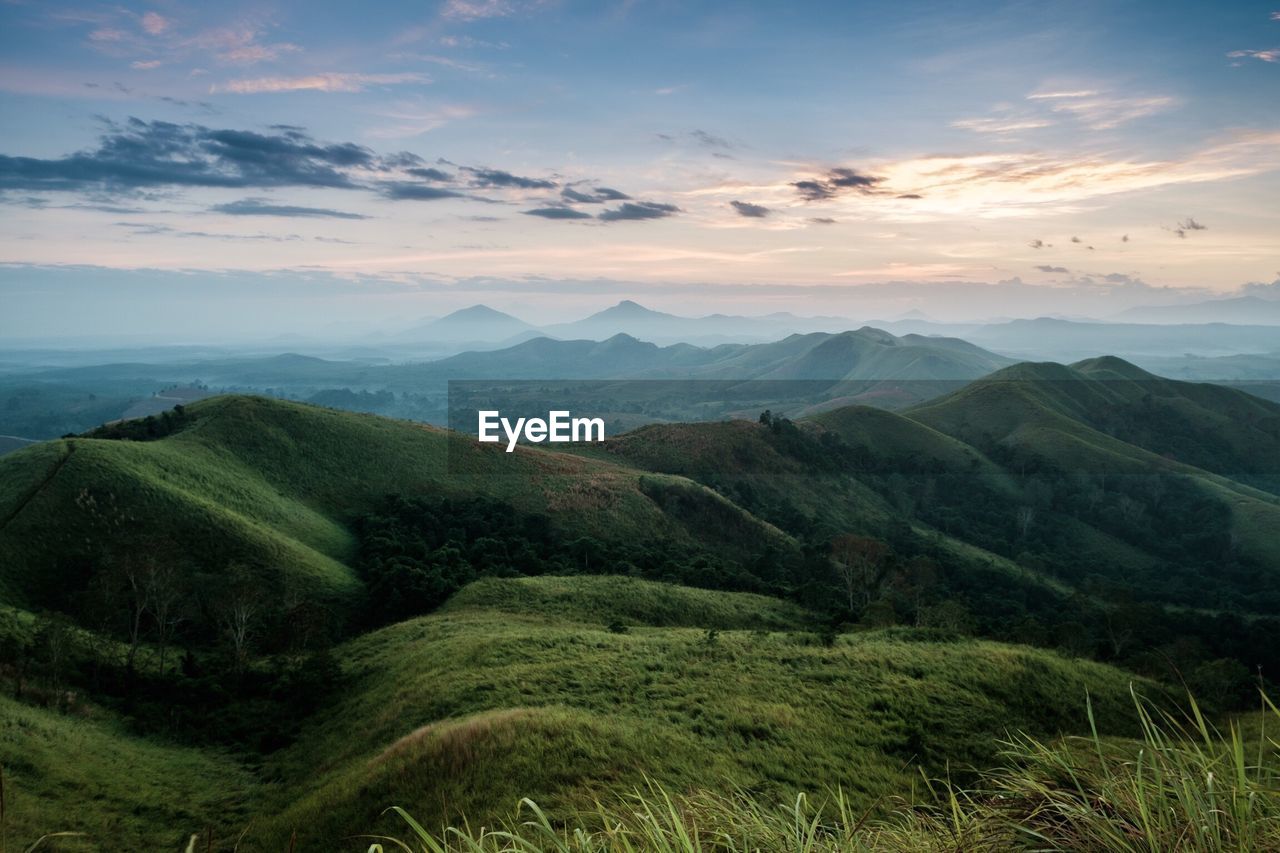 Scenic view of green mountains during sunrise