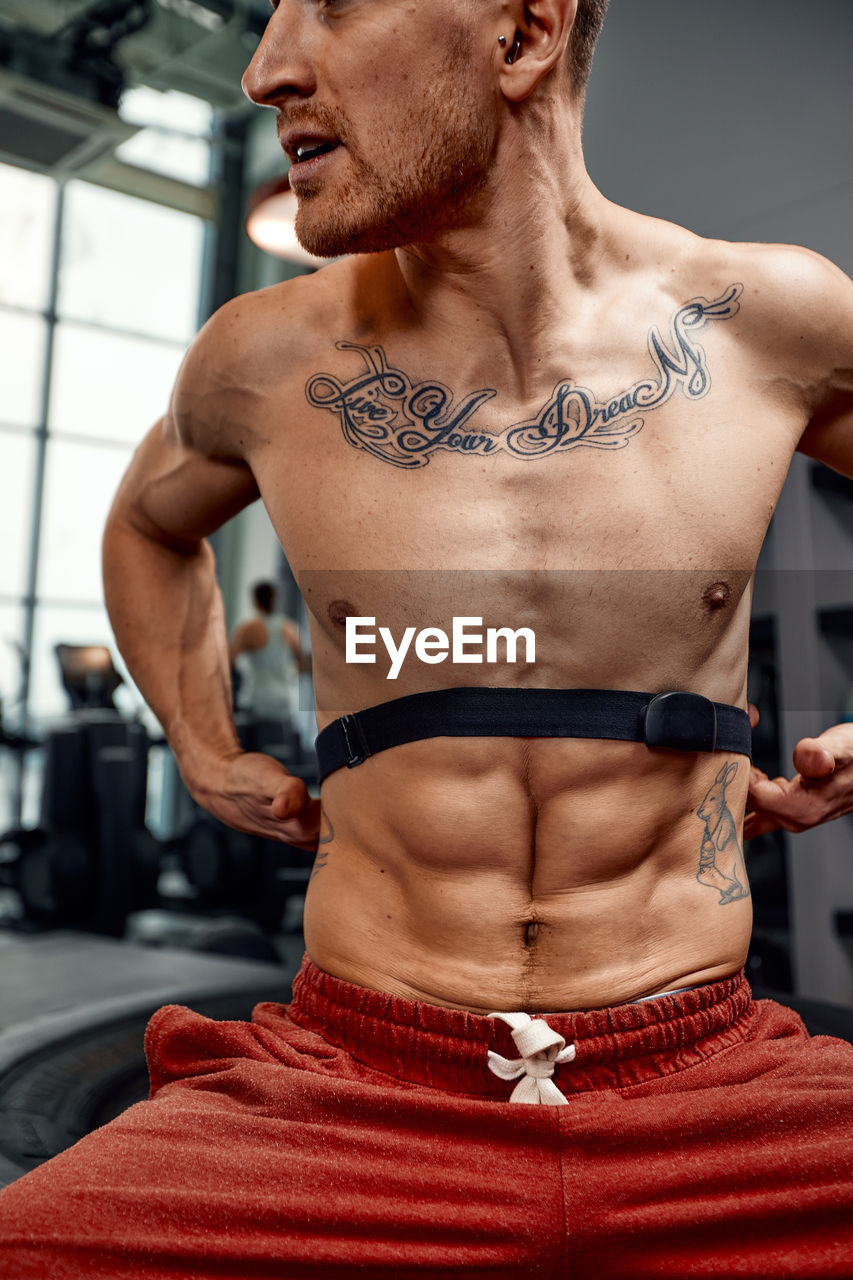 low angle view of shirtless man standing in gym