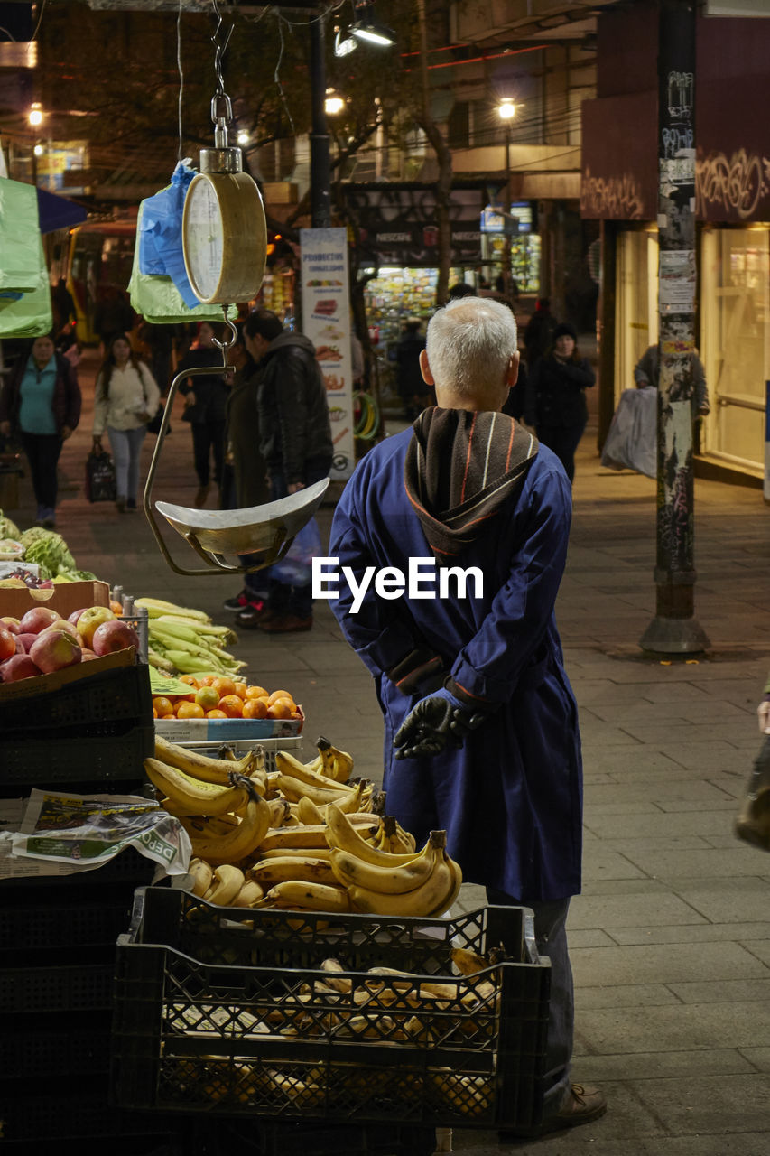 MAN PREPARING FOOD FOR SALE AT MARKET