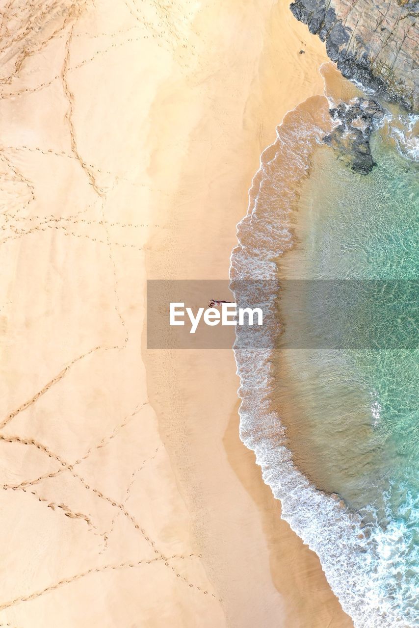 Aerial view of mid adult woman lying at beach