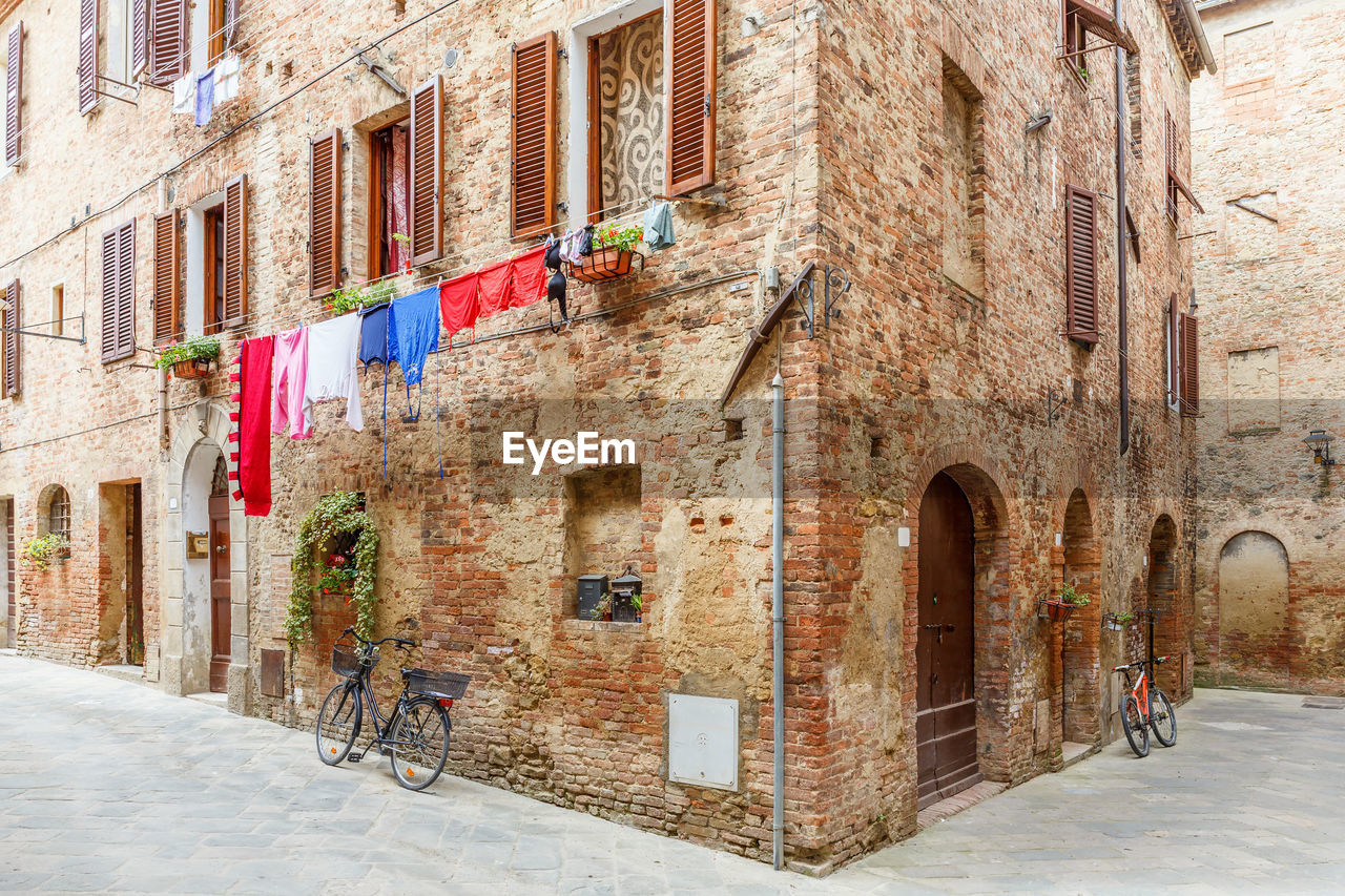 Idyllic italian alley with hanging laundry and a parked bicycles