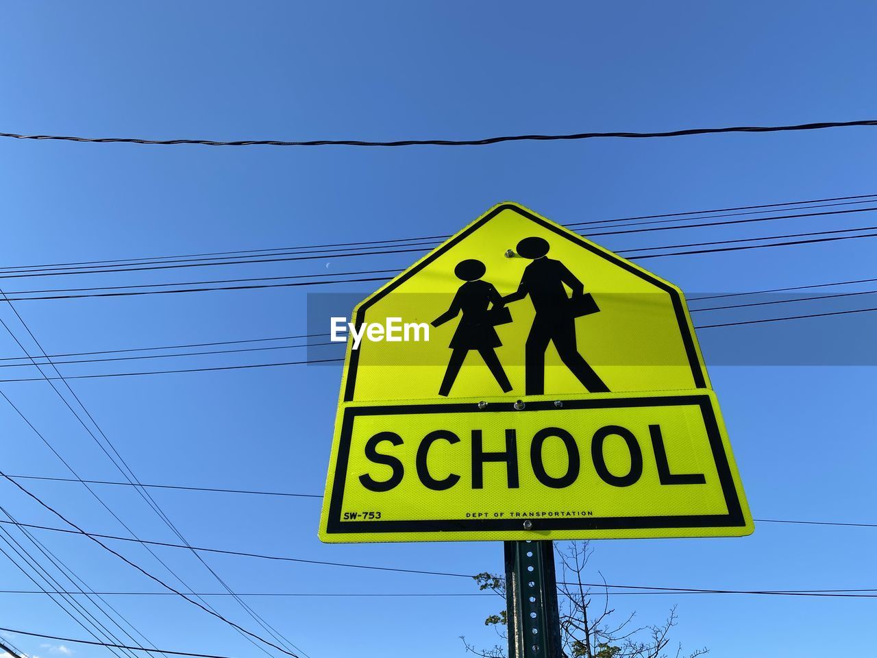 Low angle view of pedestrian crossing road sign against blue sky in mount vernon new york 