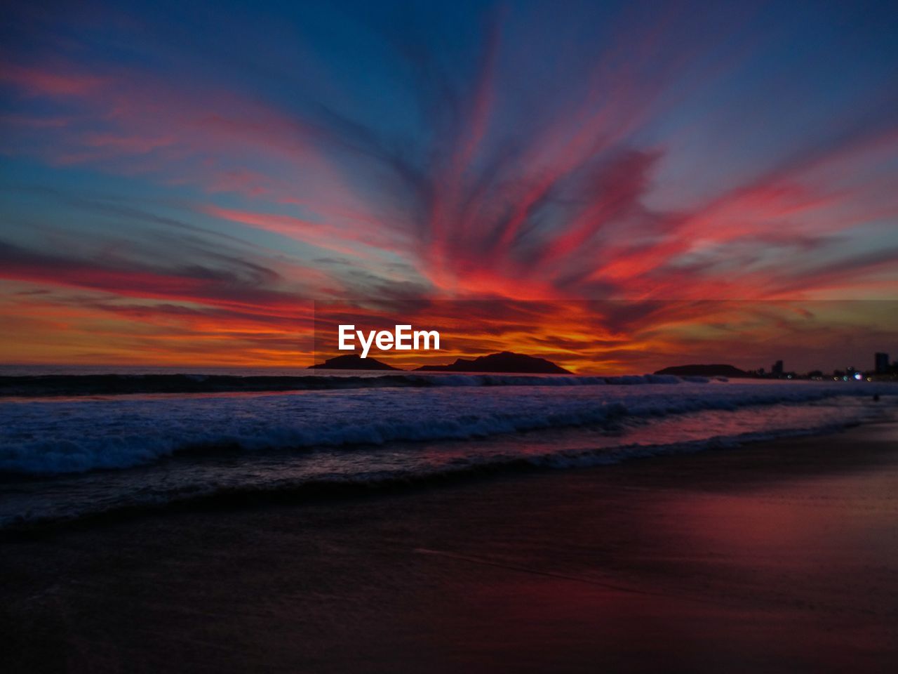 Scenic view of sea against dramatic sky during sunset