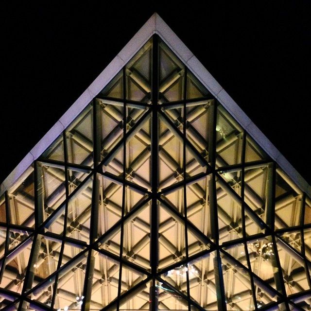 LOW ANGLE VIEW OF ILLUMINATED BUILT STRUCTURE AT NIGHT