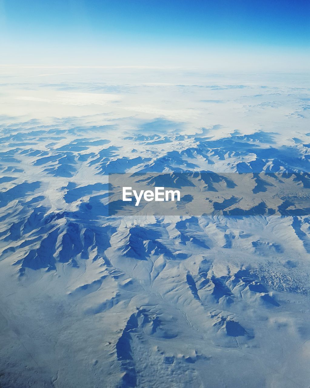 Aerial view of snowcapped mountains against sky