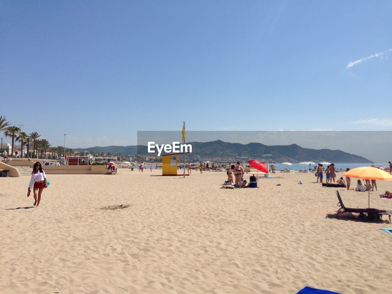 People at beach against blue sky