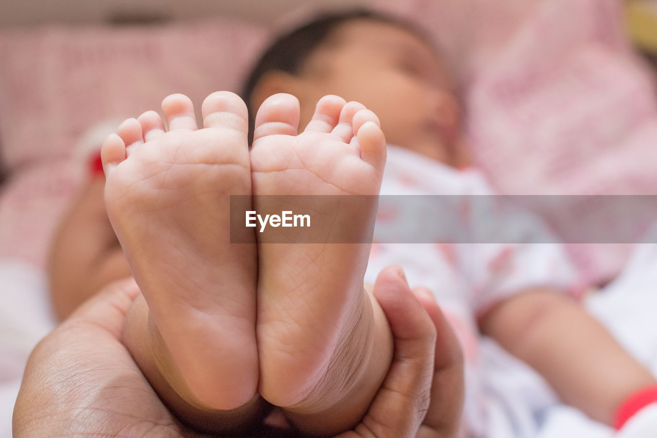 Close-up of hand holding baby feet