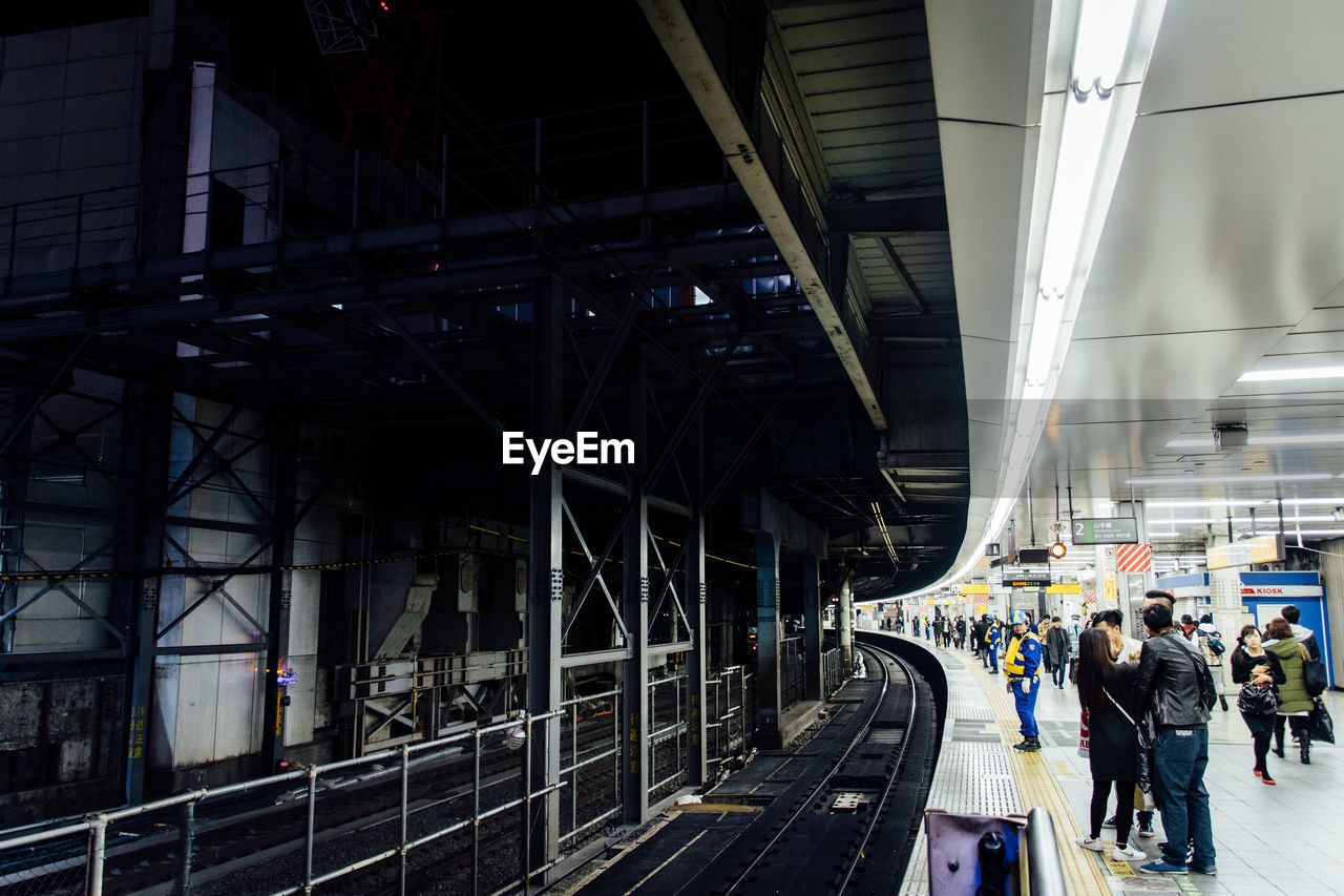 People on railroad station platform at night