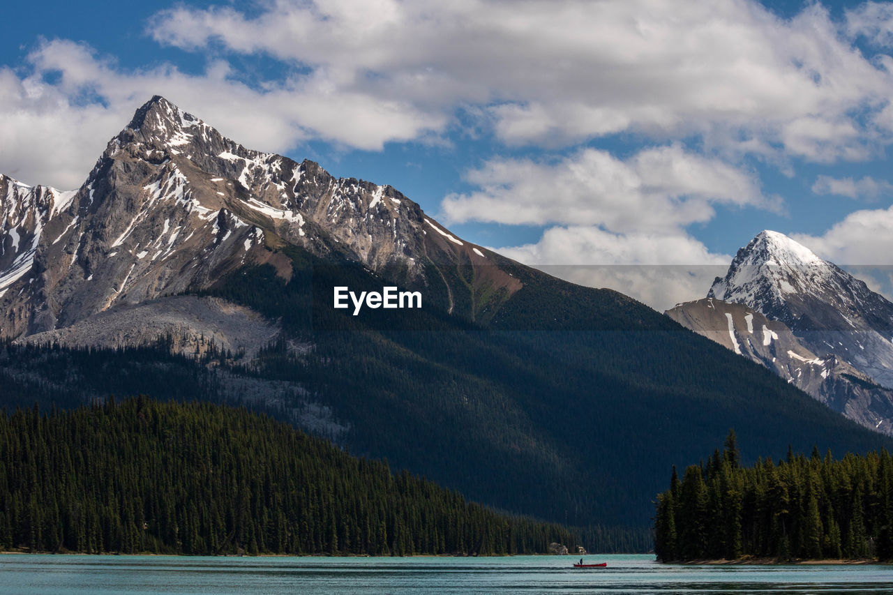 Scenic view of lake by mountains against cloudy sky during winter