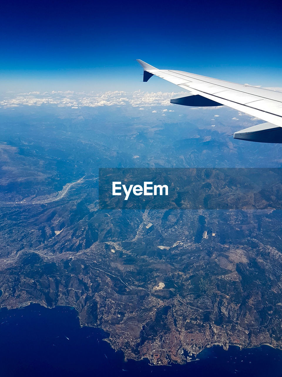 AERIAL VIEW OF AIRPLANE WING ABOVE LANDSCAPE