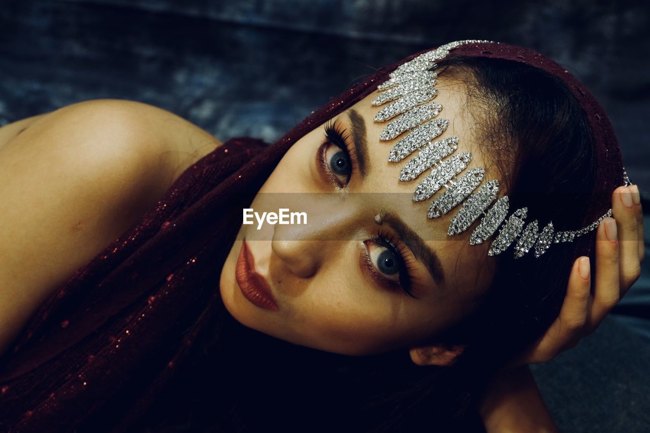 Close-up portrait of beautiful young woman wearing jewelry