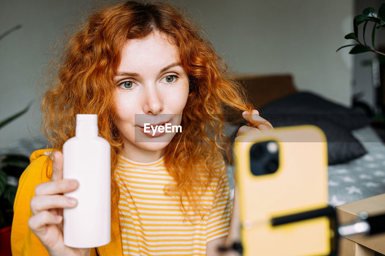 portrait of smiling young woman using mobile phone