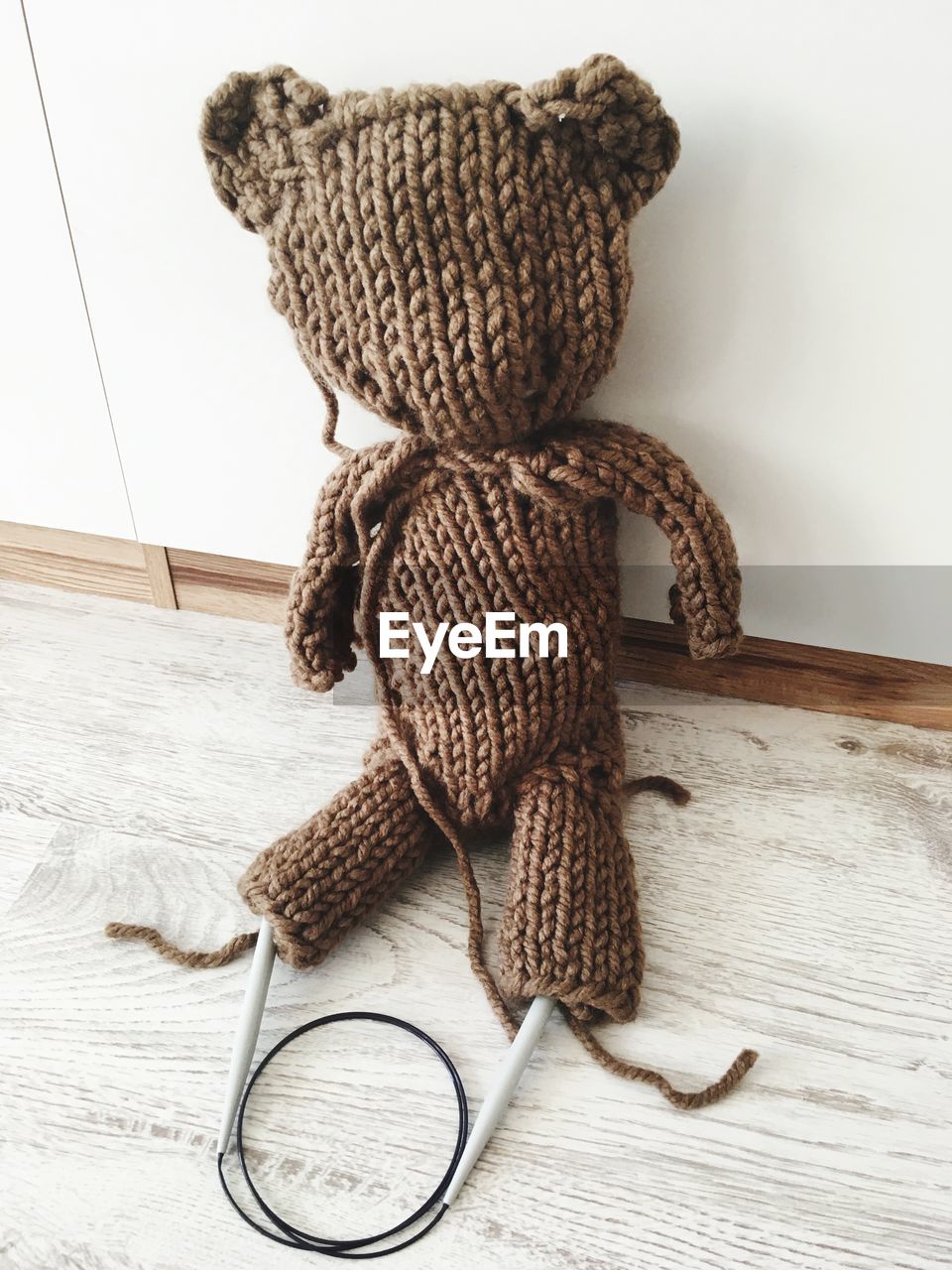 High angle view of knitted teddy bear on floor against wall at home