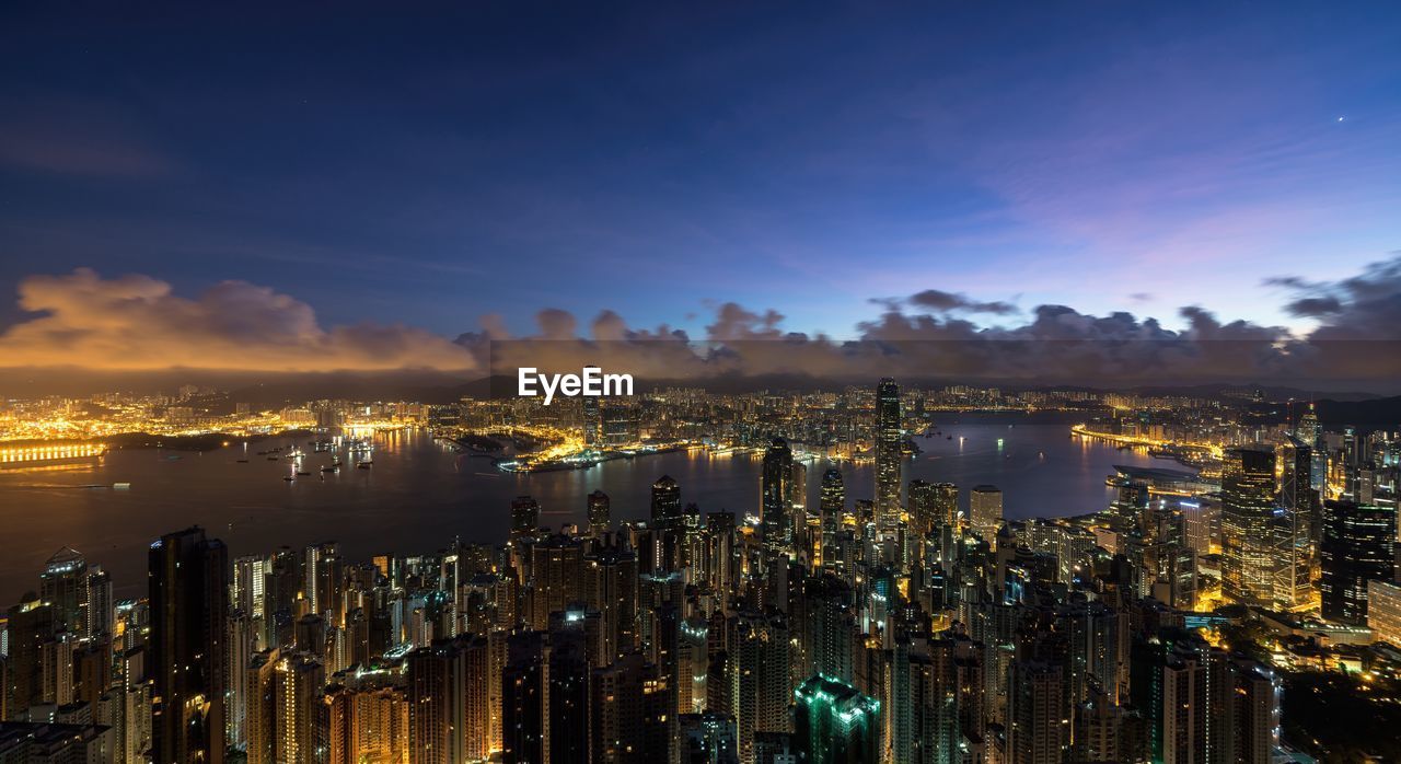 Illuminated cityscape against sky at night