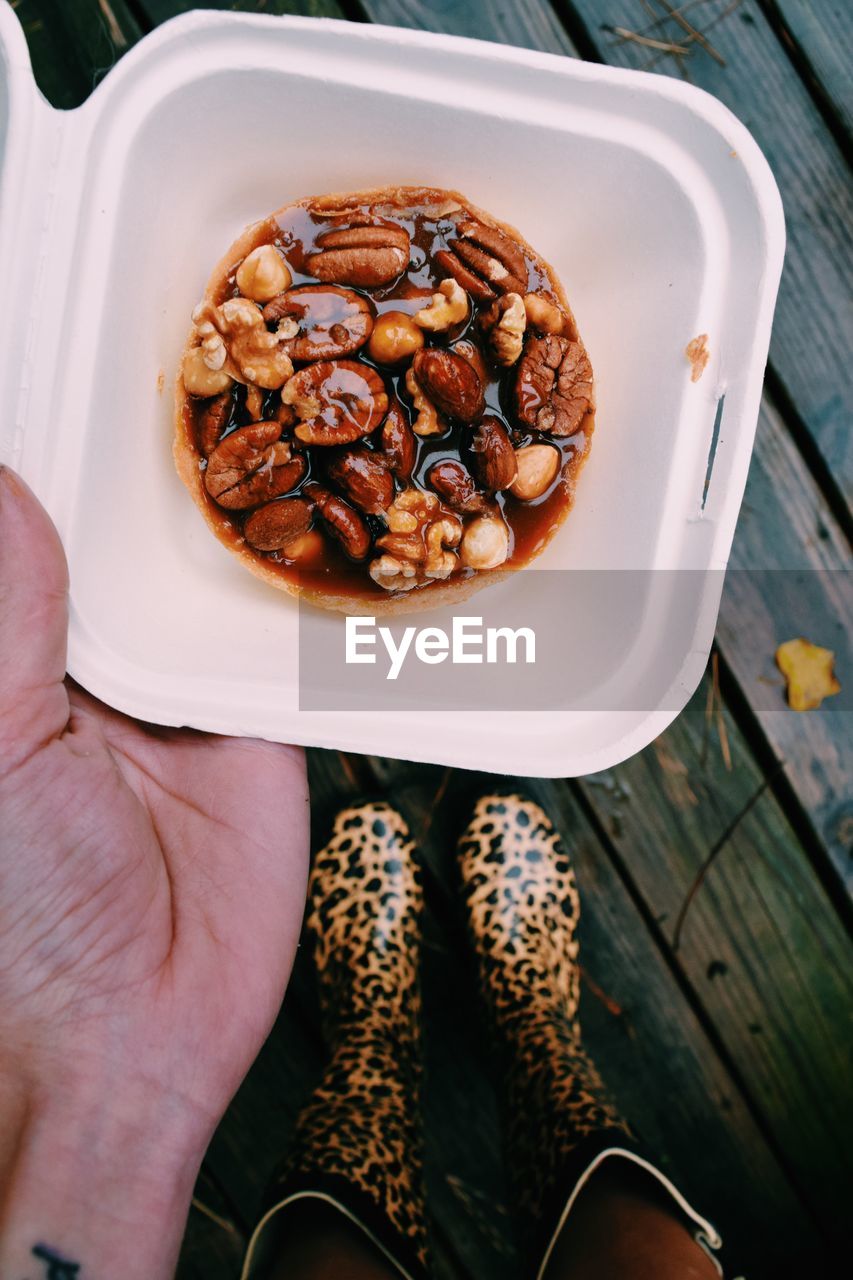 Low section of woman holding breakfast during rainy season