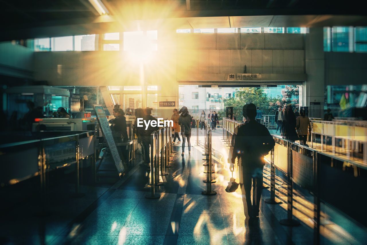 People walking at station during sunny day
