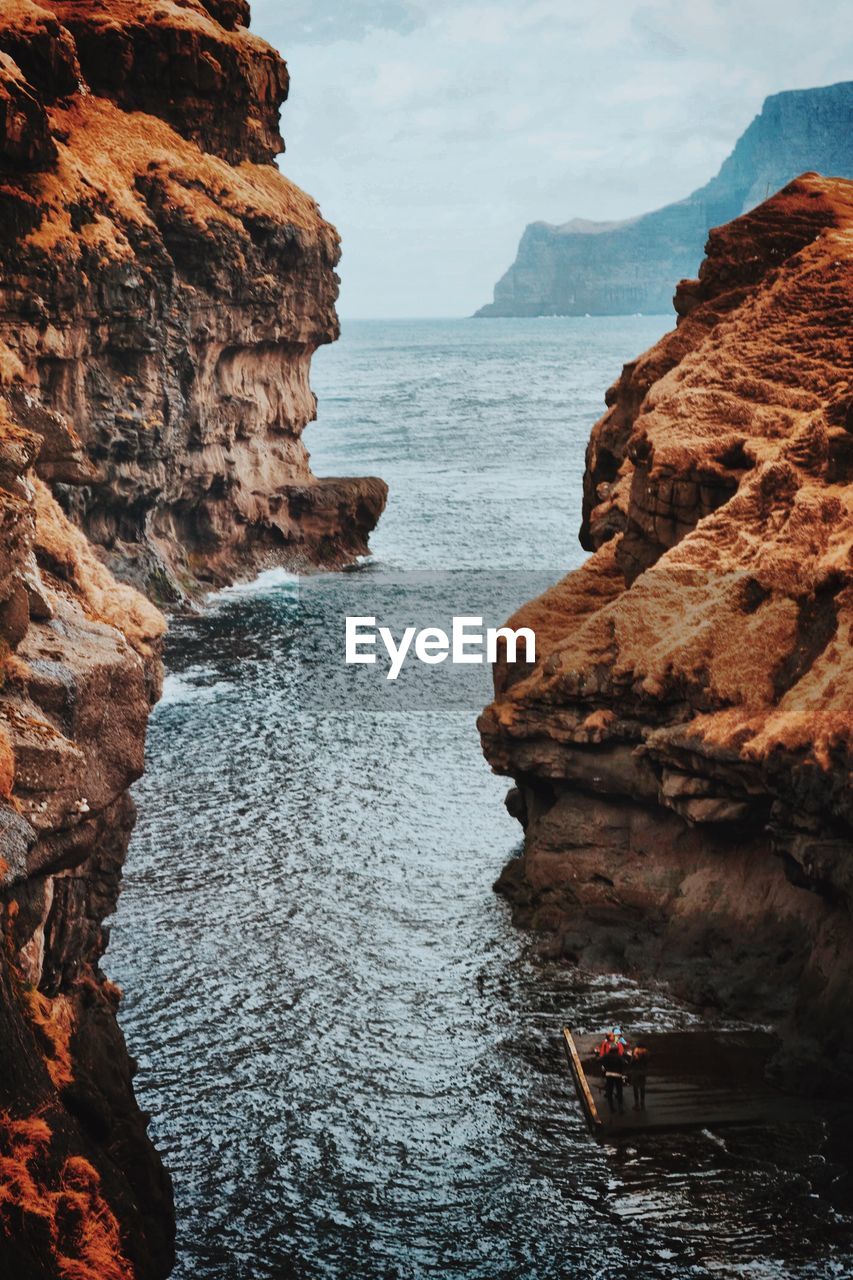 Rock formations by sea against sky