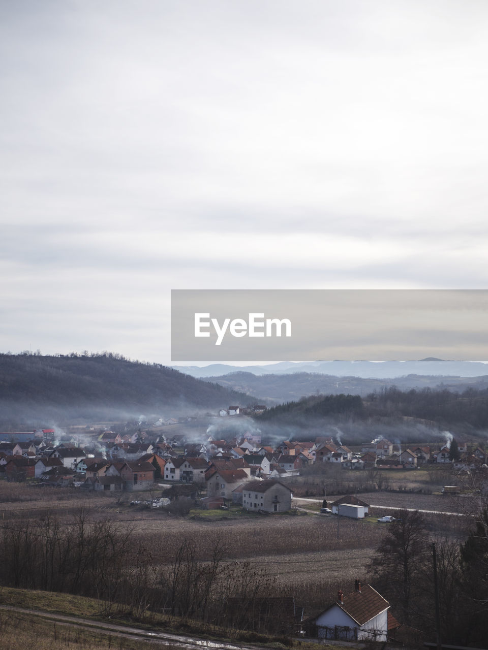 Houses by landscape against sky