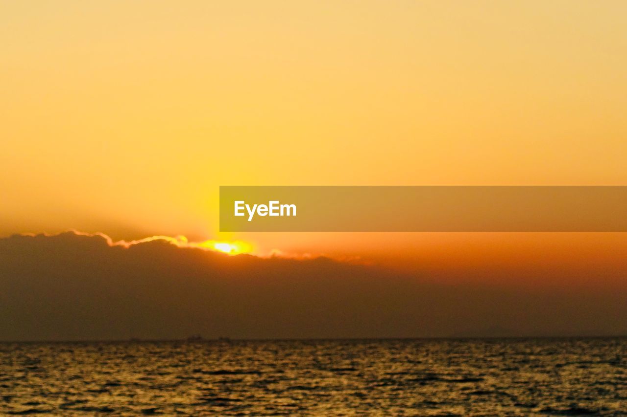 SCENIC VIEW OF SEA AGAINST SKY AT SUNSET