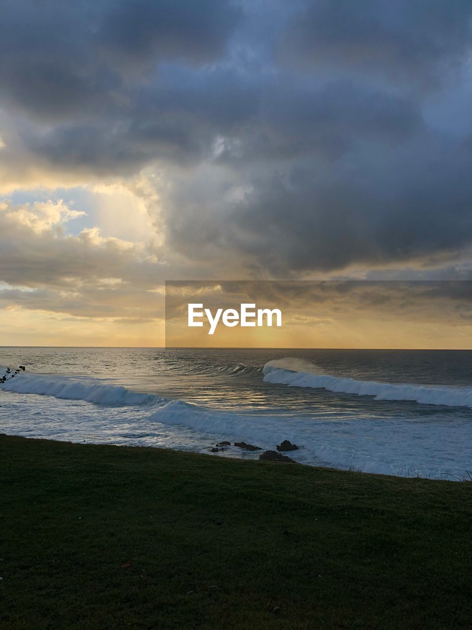 SCENIC VIEW OF BEACH AGAINST SKY AT SUNSET