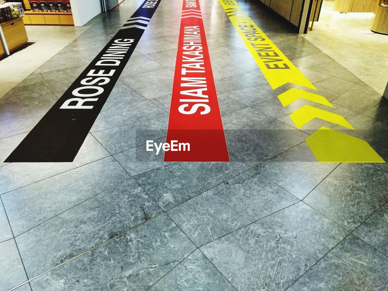 HIGH ANGLE VIEW OF ROAD SIGNS ON FOOTPATH