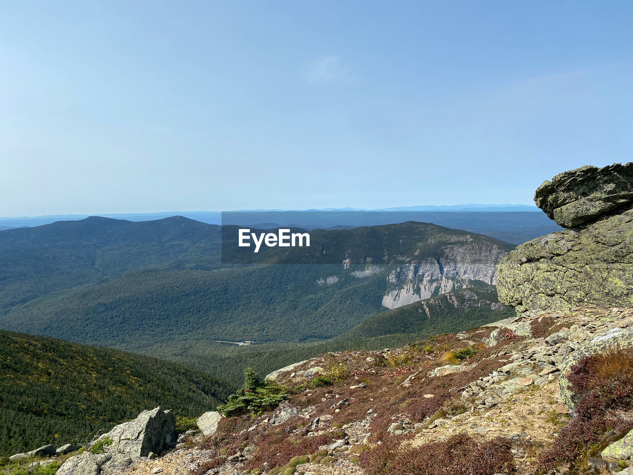 Scenic view of landscape and mountains against clear blue sky