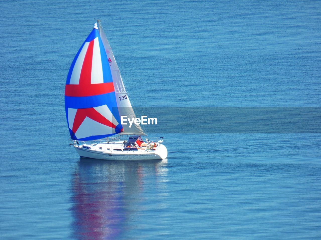 BOAT SAILING IN SEA AGAINST BLUE SKY