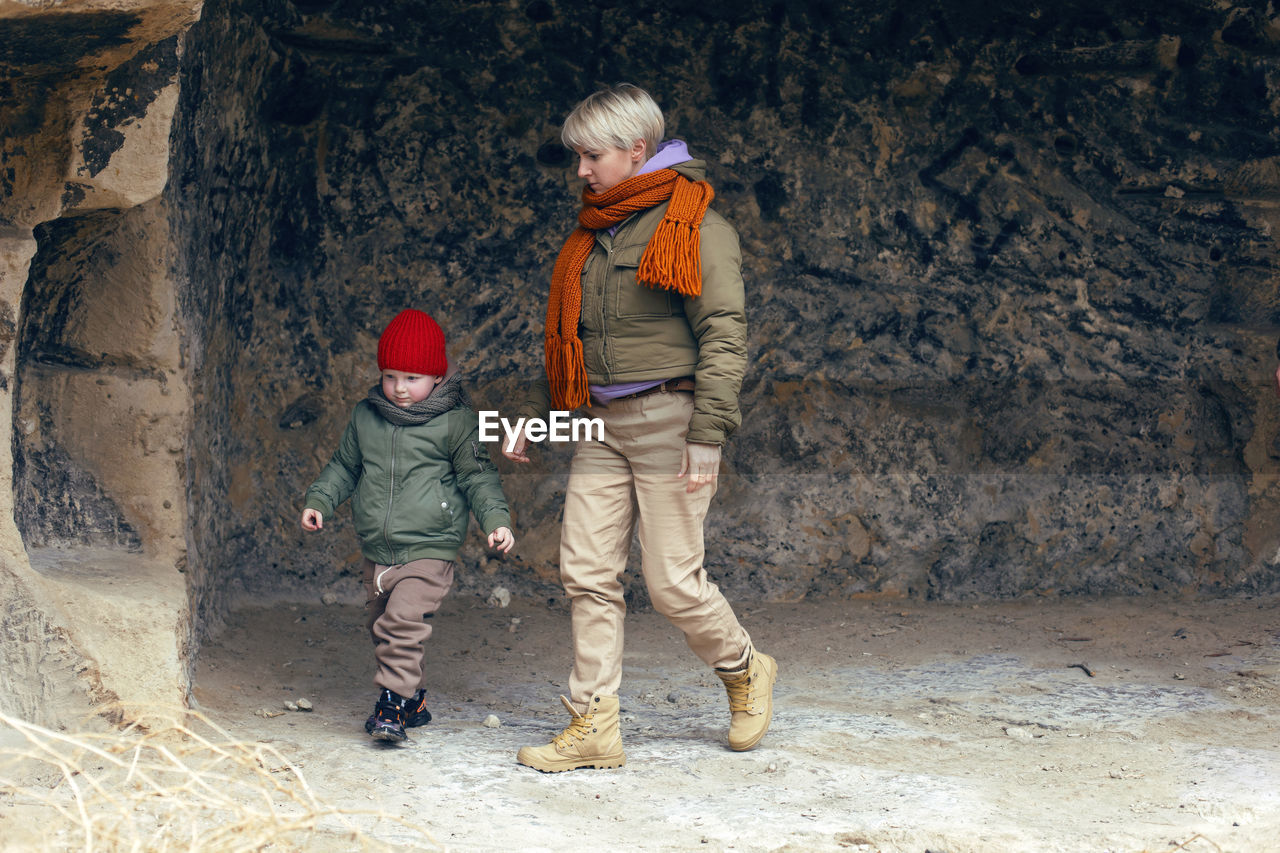 Mom walks with her child in the fall in the rock