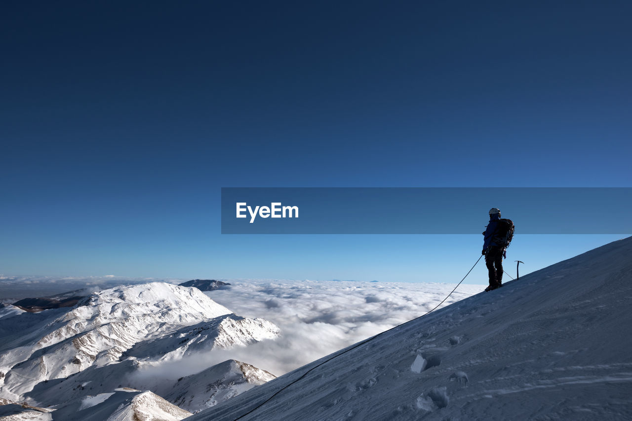 Man standing on snowcapped cervino mountain against clear sky