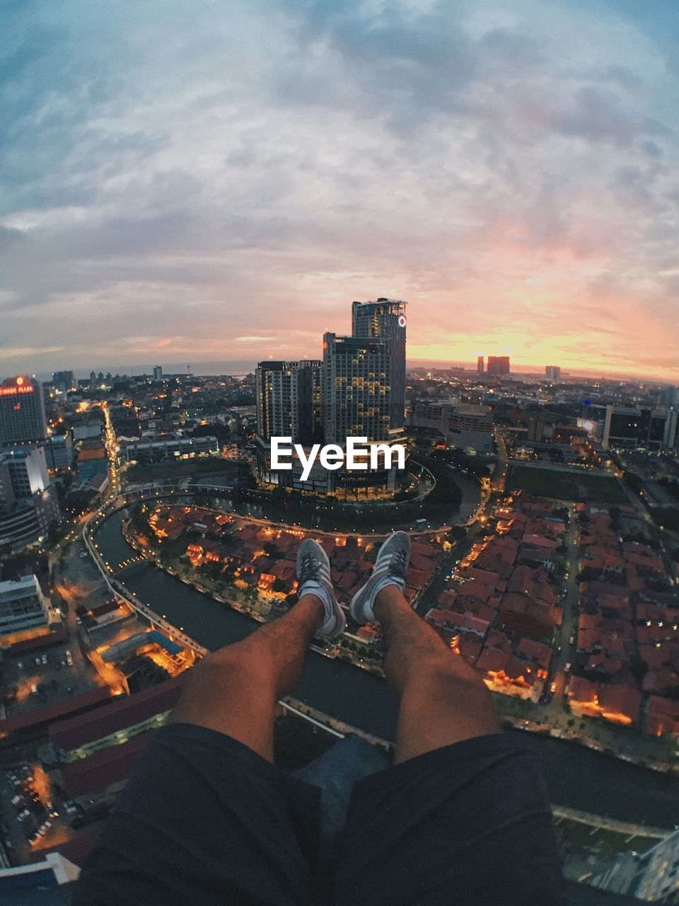 Low section of man and cityscape against sky