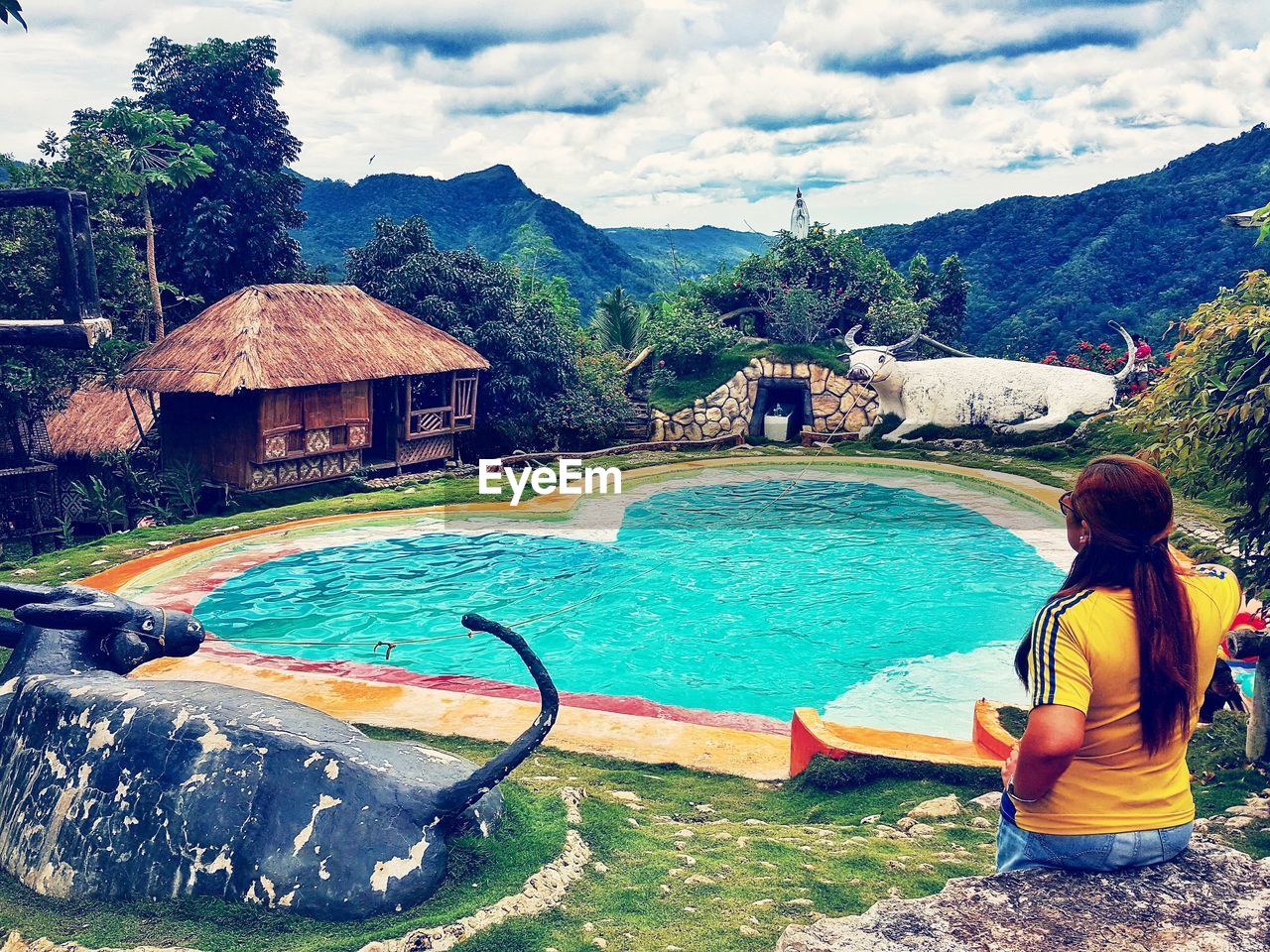 FULL LENGTH OF MAN IN SWIMMING POOL AGAINST MOUNTAINS