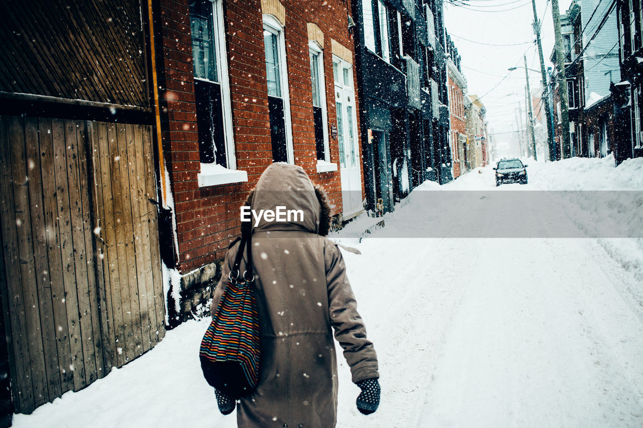 Rear view of woman walking in snow