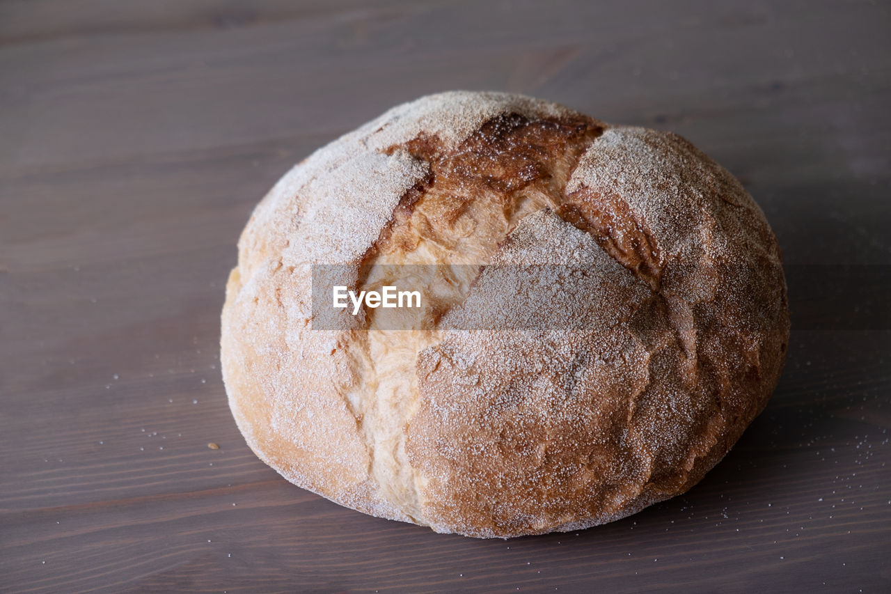 Loaf of freshly baked homemade artisan bread on a wooden surface. selective focus.