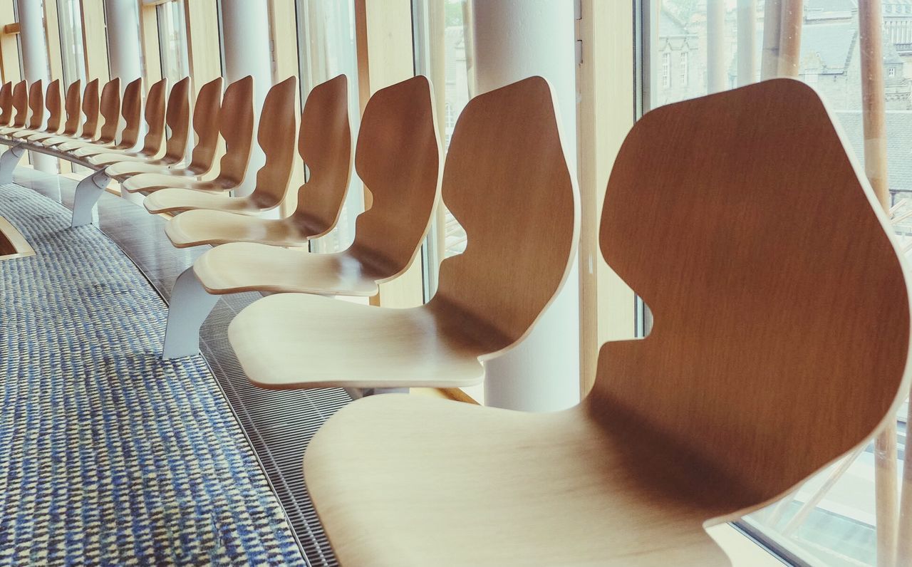 Empty wooden seats in row at scottish parliament