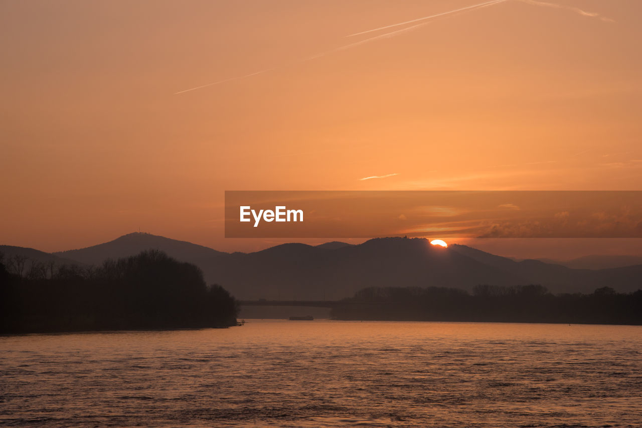 Scenic view of lake against sky during sunset