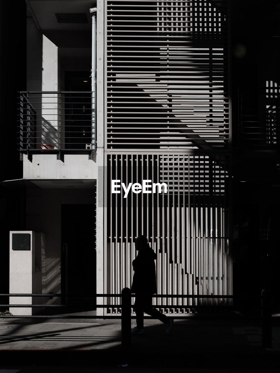 black, architecture, white, one person, built structure, full length, black and white, building exterior, monochrome, light, city, darkness, adult, monochrome photography, silhouette, men, building, walking, lifestyles, city life, rear view, street, shadow, outdoors, interior design, standing