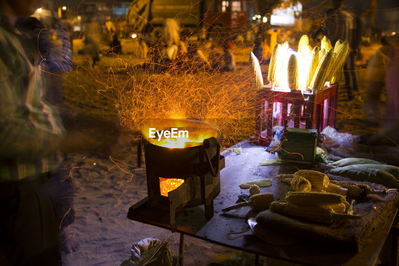 Blurred motion of man preparing corn on bonfire