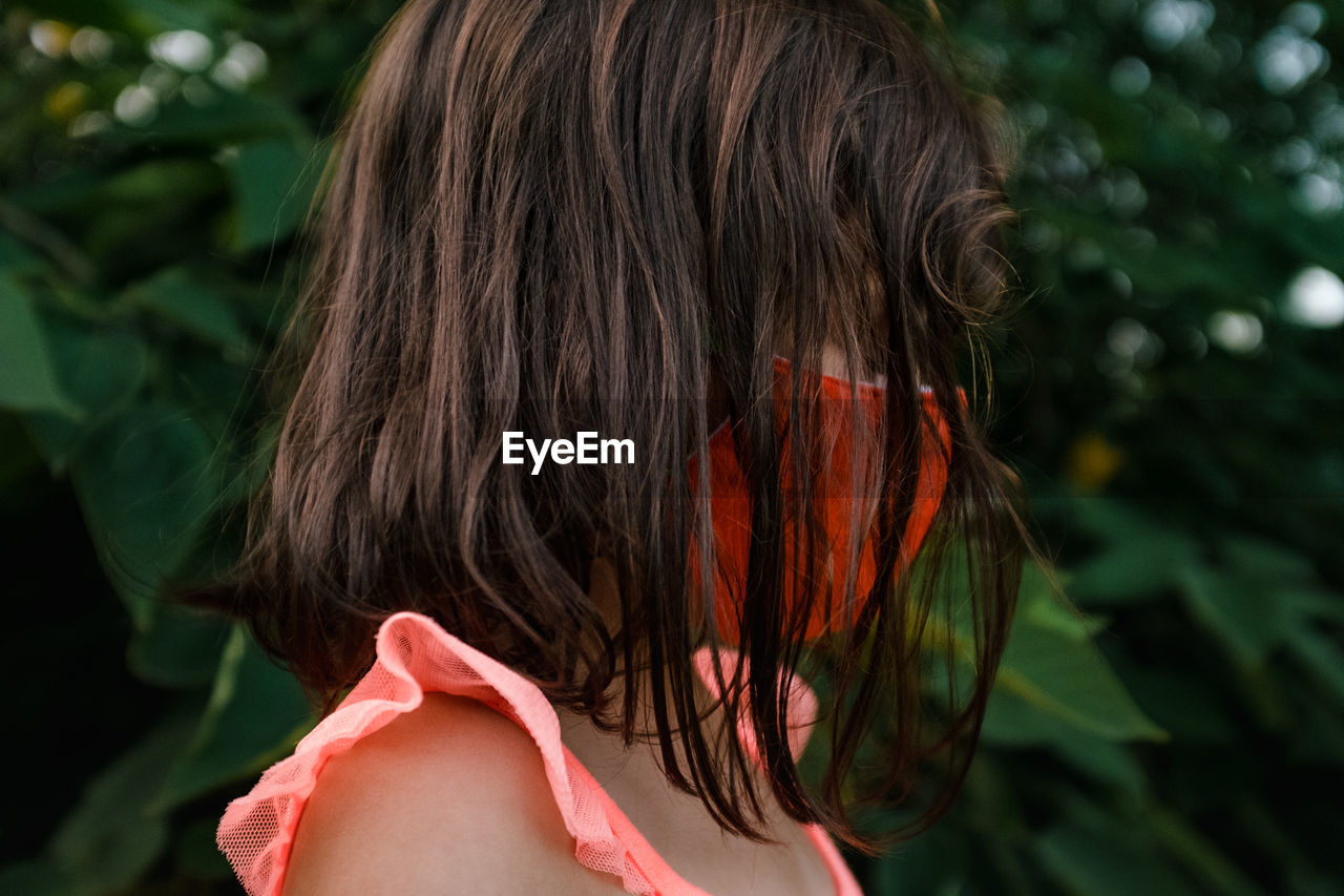 Little girl in mask with messy hair