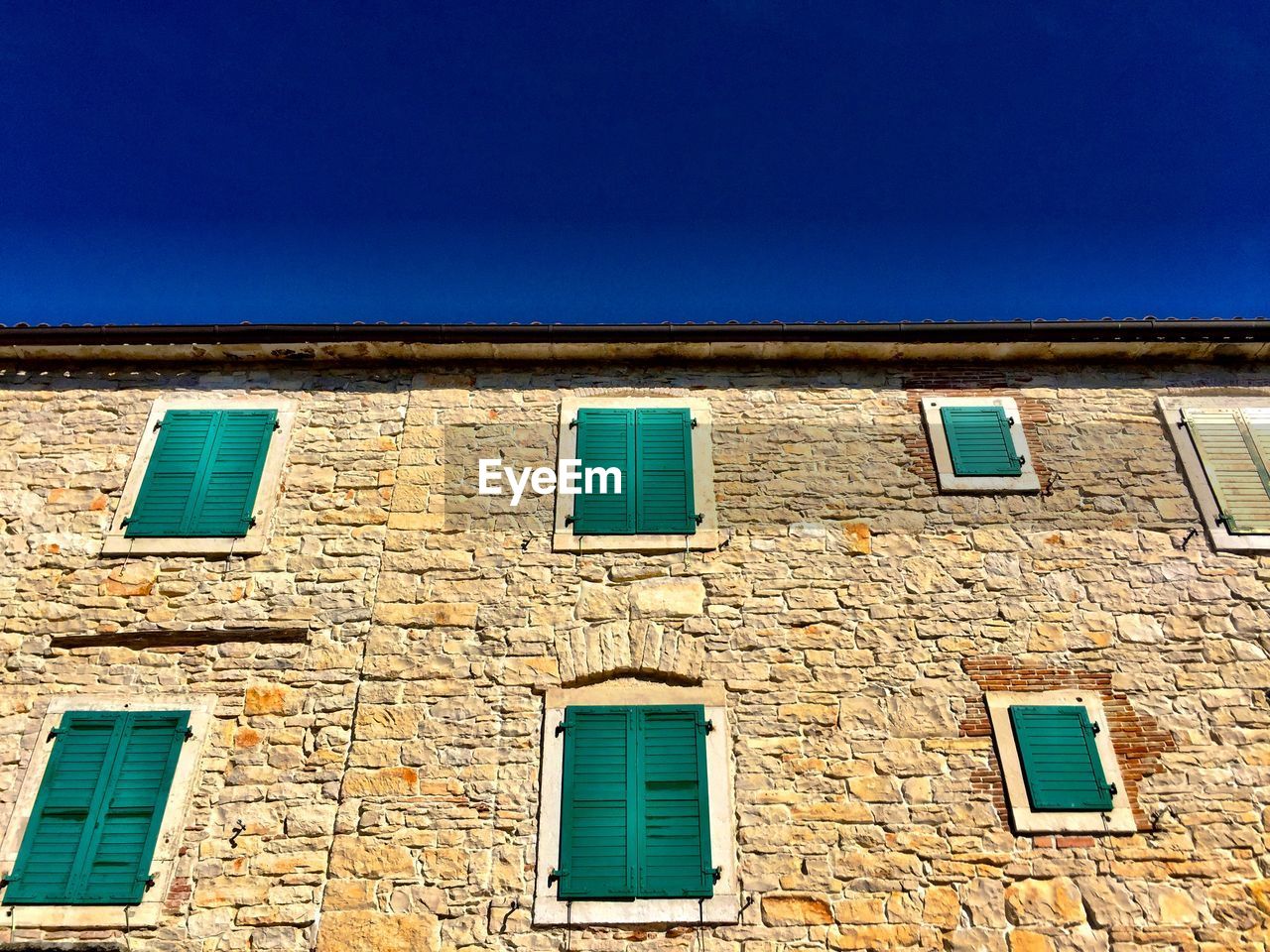 Low angle view of building against clear blue sky