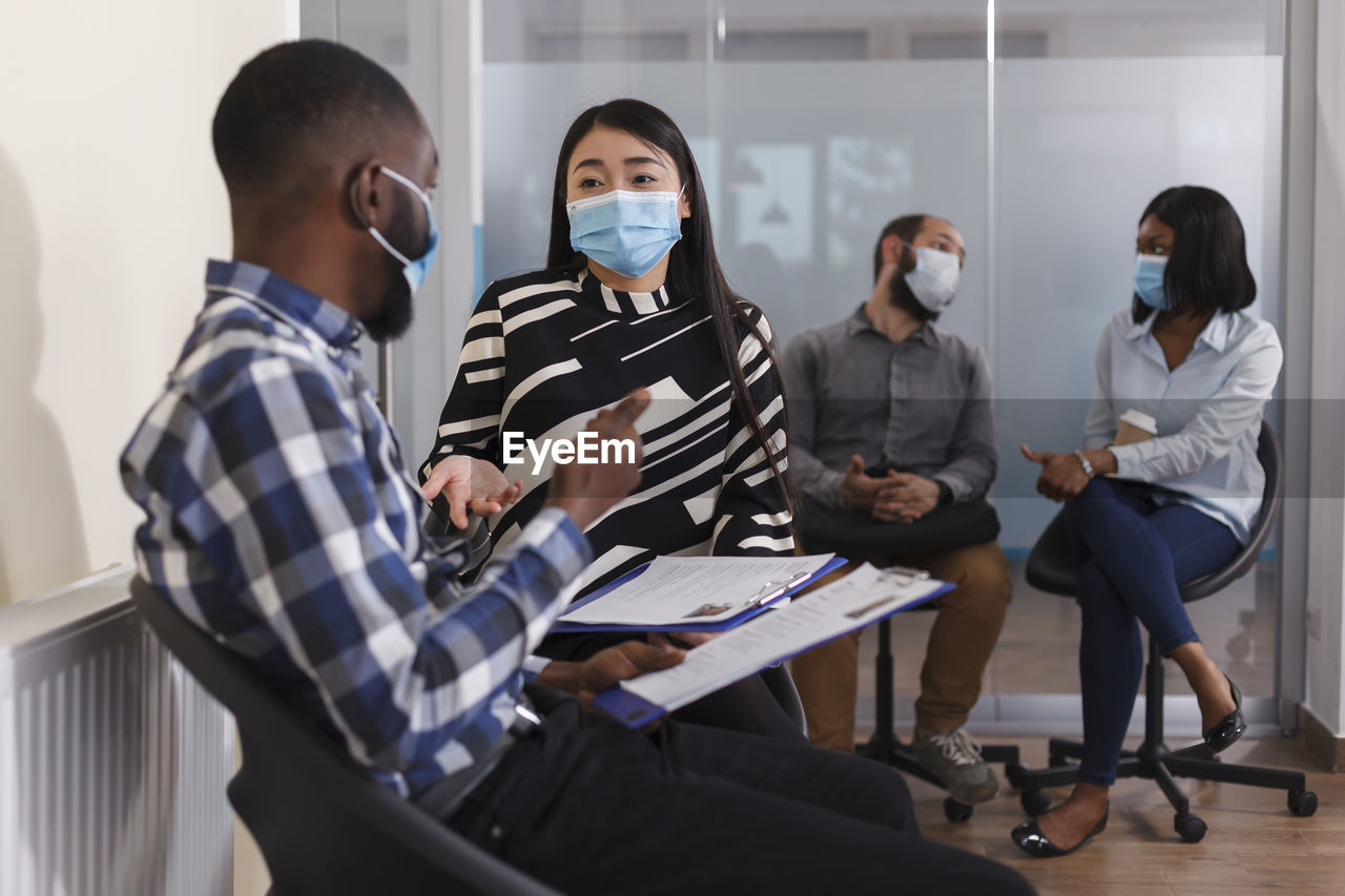 Interviewer wearing mask talking with candidate in office