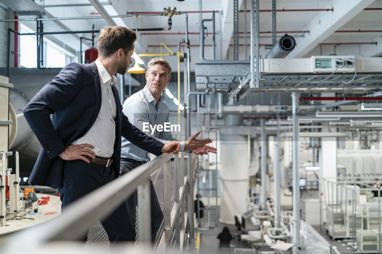 Two businessmen talking in a modern factory