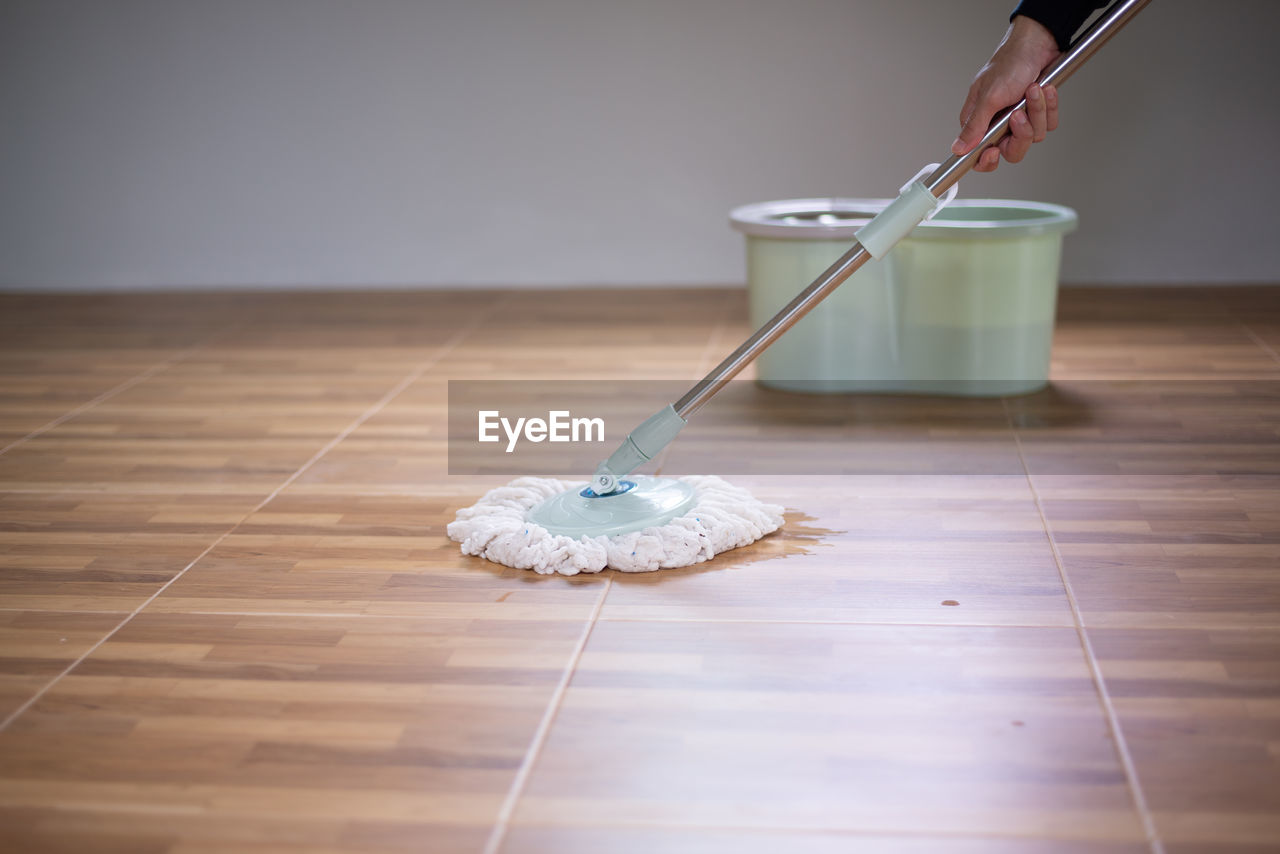 WOMAN HOLDING UMBRELLA ON HARDWOOD FLOOR