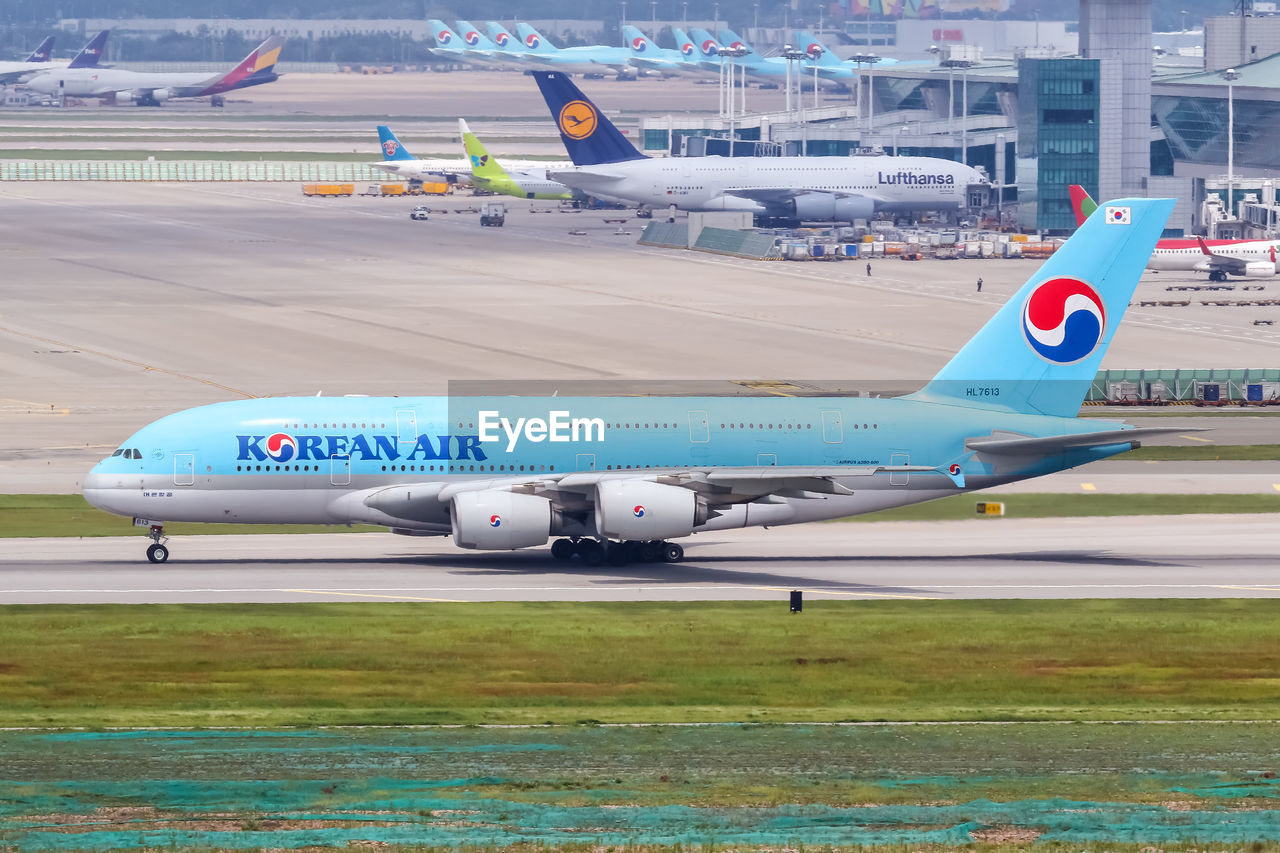 AIRPLANE FLYING OVER RUNWAY