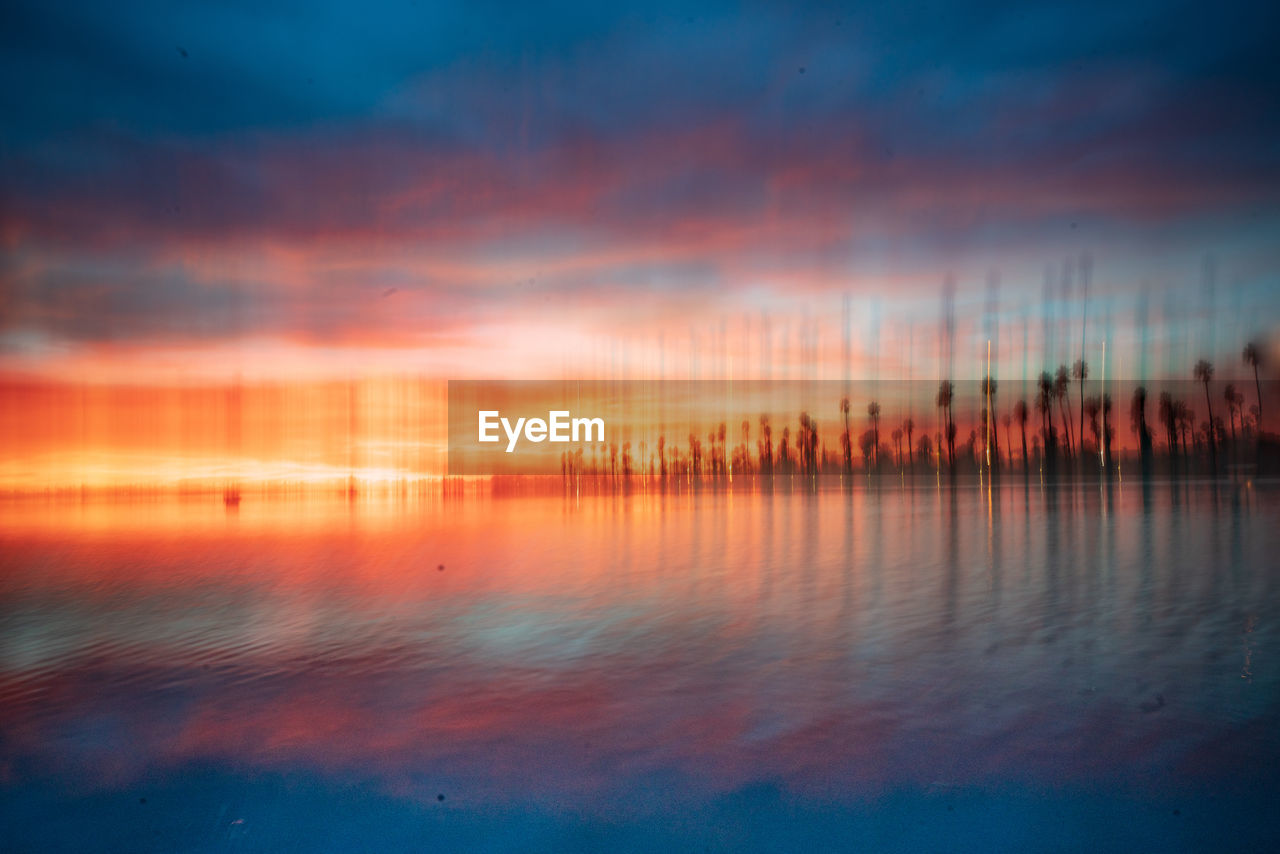 Scenic view of lake against sky at sunset