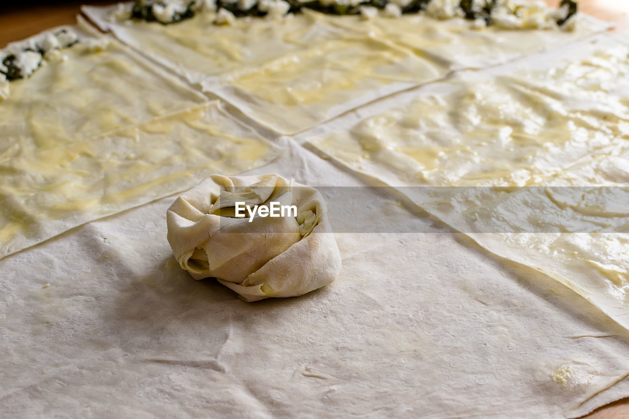 Sheets of dough for twisted patties with dock and white cheese on the table