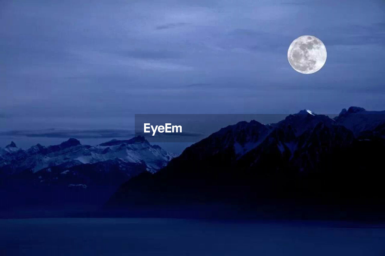 Scenic view of mountain against full moon in sky at night