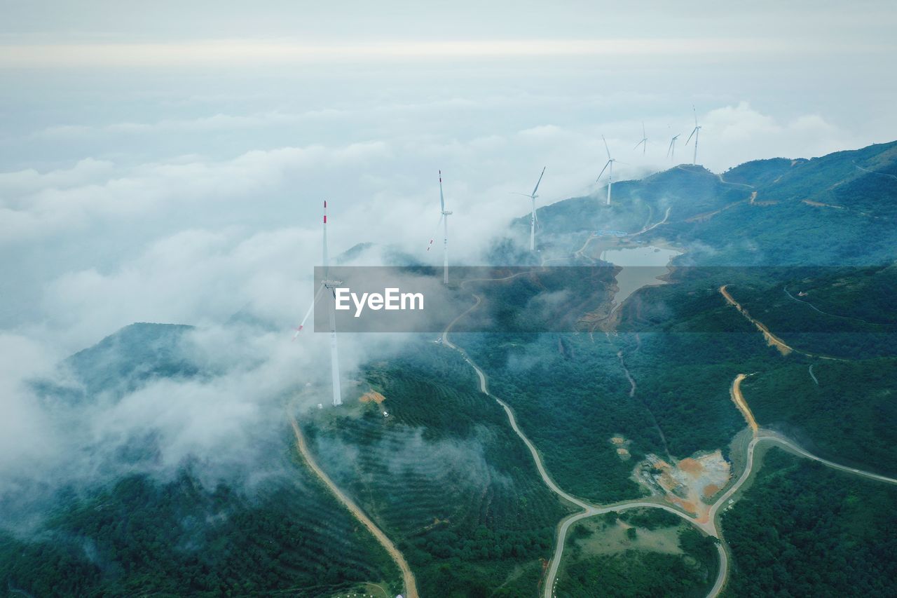Aerial view of windmills on landscape against sky