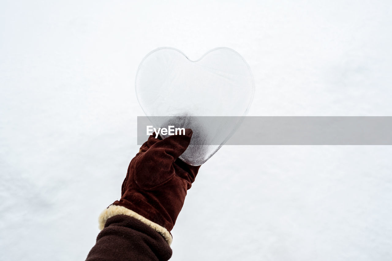 low section of woman holding heart shape